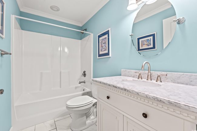 Bathroom featuring vanity, crown molding, marble finish floors, and shower combination | Image 17