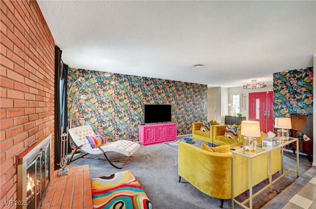Living area with a textured ceiling, a brick fireplace, carpet, and wallpapered walls | Image 7