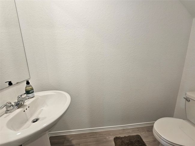 Half bath with toilet, a sink, wood finished floors, and baseboards | Image 29