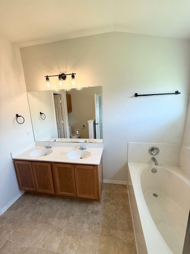 Full bathroom featuring a garden tub, double vanity, and tile patterned floors | Image 9