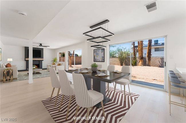 Dining area with a lit fireplace and ceiling fan | Image 13