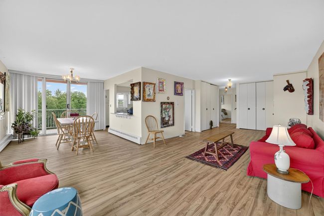 Living room featuring a chandelier, wood finished floors, and a baseboard radiator | Image 11