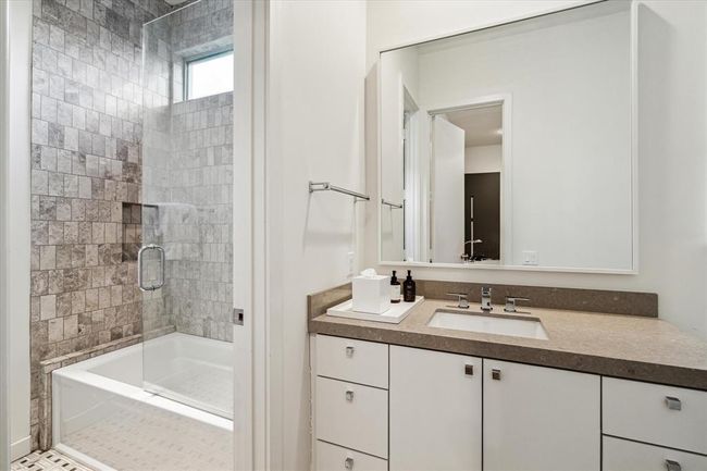SHARED BATH for #2 and #3 Bedrooms - decorative tile flooring, stone counter/backsplash, Kohler sink with decorative sink, cabinets/drawers below, metal framed mirror, tub/shower with subway tile surround, horizontal window/glass half partition, decorative tile flooring, recessed lighiting. | Image 33