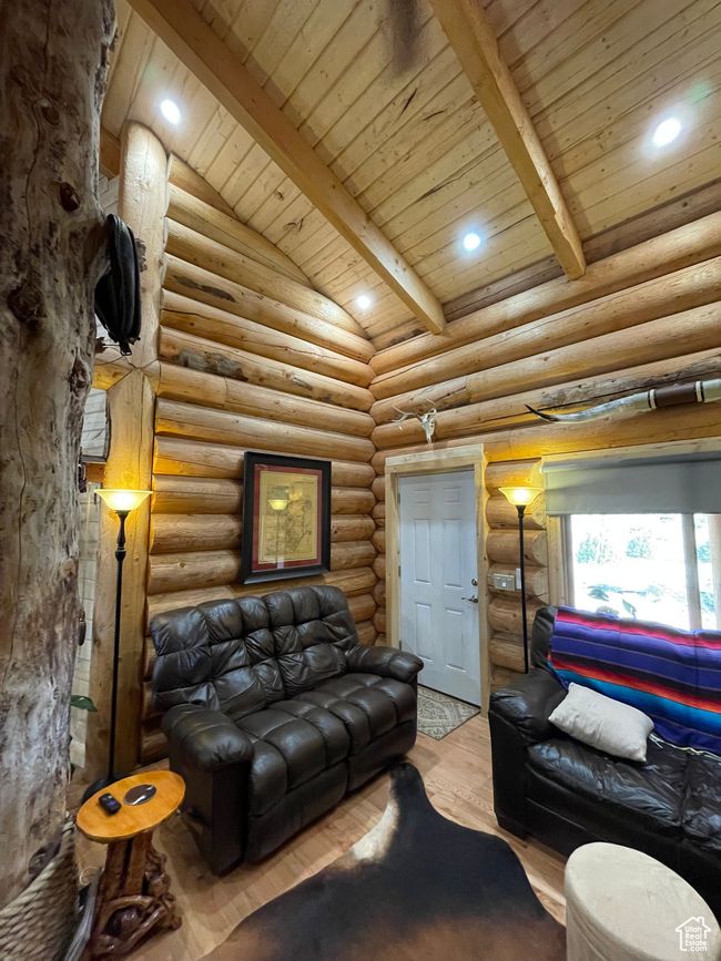 Living area featuring lofted ceiling with beams, log walls, wood finished floors, recessed lighting, and wood ceiling | Image 64