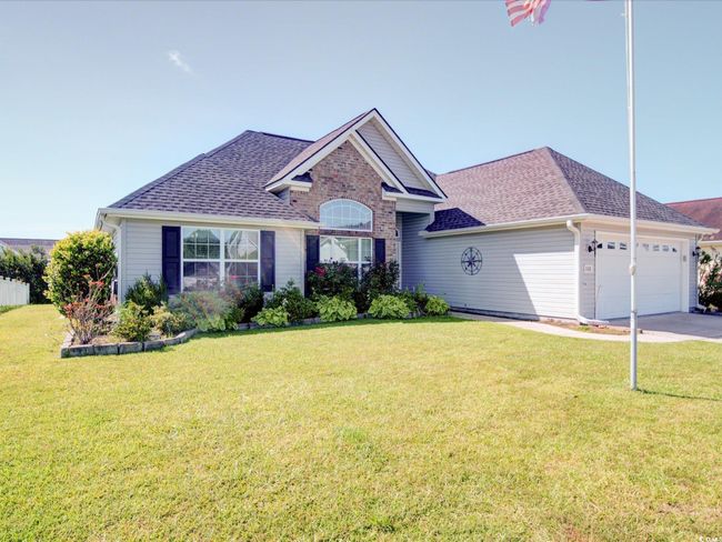 View of front facade with an attached garage, roof with shingles, a front lawn, and driveway | Image 7