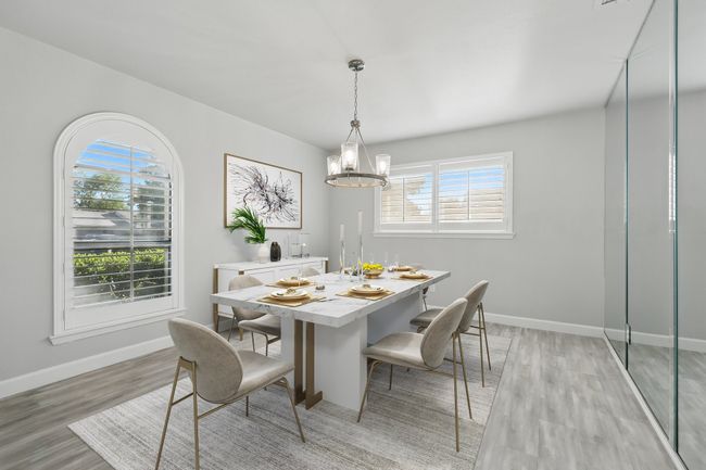 Dining area with healthy amount of natural light, a chandelier, light wood-style flooring, and baseboards | Image 4