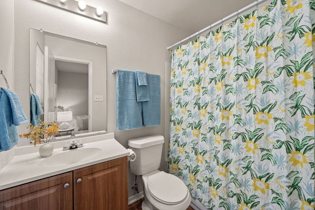 Combo tub/shower and vanity in the primary bathroom with a window allowing for natural light overlooking the backyard. | Image 20