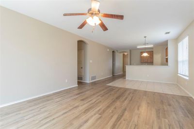 Unfurnished living room featuring ceiling fan and light hardwood / wood-style flooring | Image 3