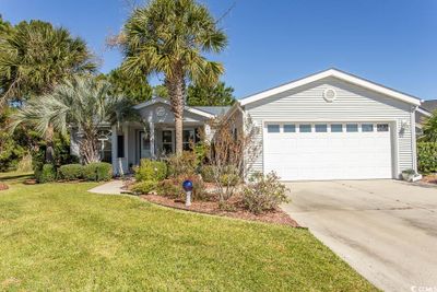 Single story home featuring a front yard and a garage | Image 1