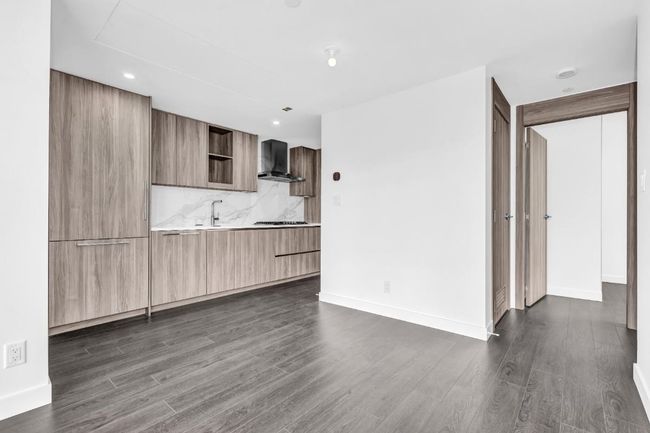 Kitchen with modern cabinets, wall chimney range hood, dark wood-style flooring, open shelves, and recessed lighting | Image 5