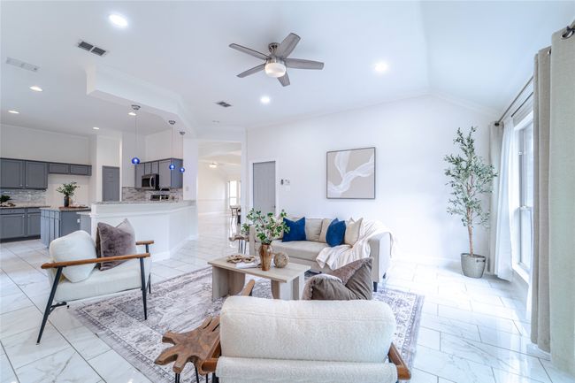 Living area featuring ceiling fan, ornamental molding, light marble finish flooring, lofted ceiling, and recessed lighting | Image 15
