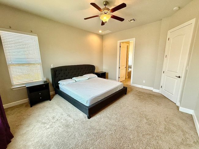 Carpeted bedroom with baseboards, ensuite bathroom, and ceiling fan | Image 9