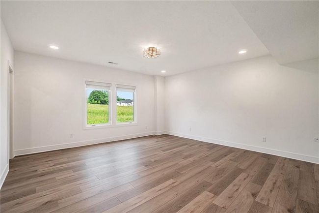 Unfurnished room with wood finished floors, recessed lighting, and baseboards | Image 50