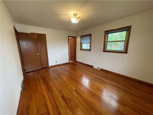 Unfurnished bedroom featuring visible vents, wood finished floors, and baseboards | Image 16