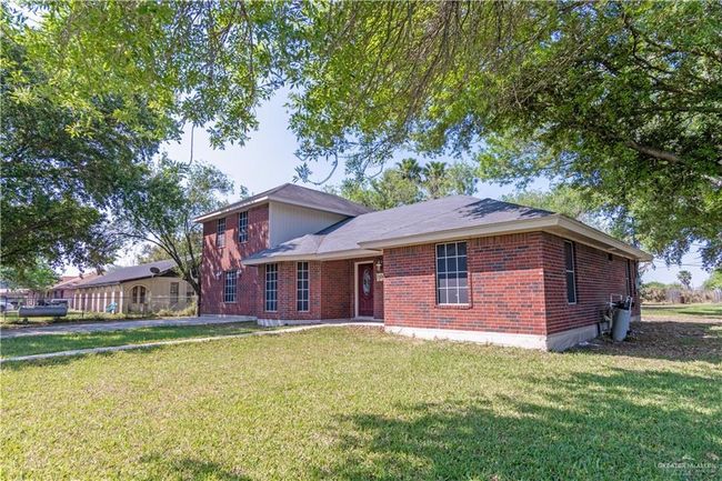 View of front of house with brick siding and a front lawn | Image 4