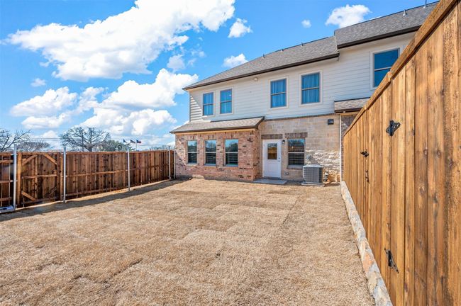 Rear view of property featuring roof with shingles, a fenced backyard, and brick siding | Image 20