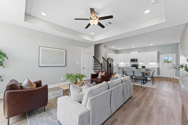 Open-concept living area featuring high ceilings, LED lighting, and plenty of natural light | Image 7