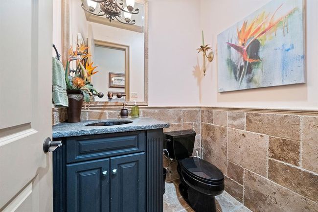 Powder room with travertine surround located on main level for convenience | Image 17