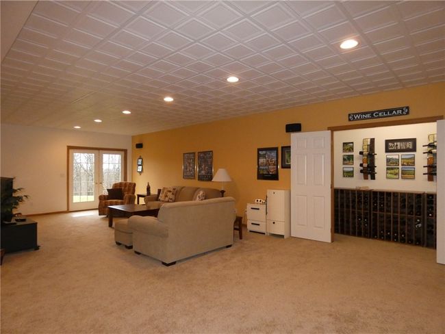 The lower level features a sprawling game room area that walks out to the side yard via French doors | Image 38