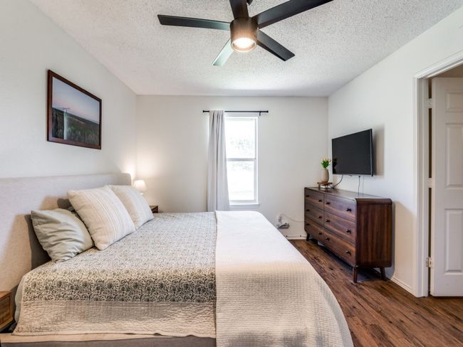 Bedroom featuring dark wood finished floors, a textured ceiling, and a ceiling fan | Image 22