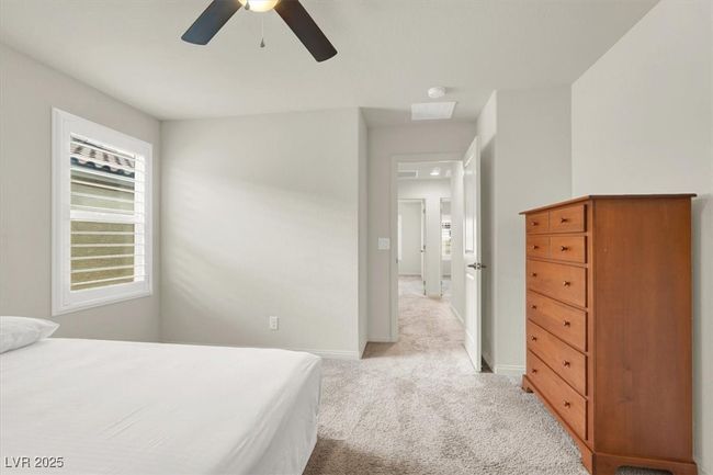 Bedroom with light colored carpet, multiple windows, and ceiling fan | Image 45