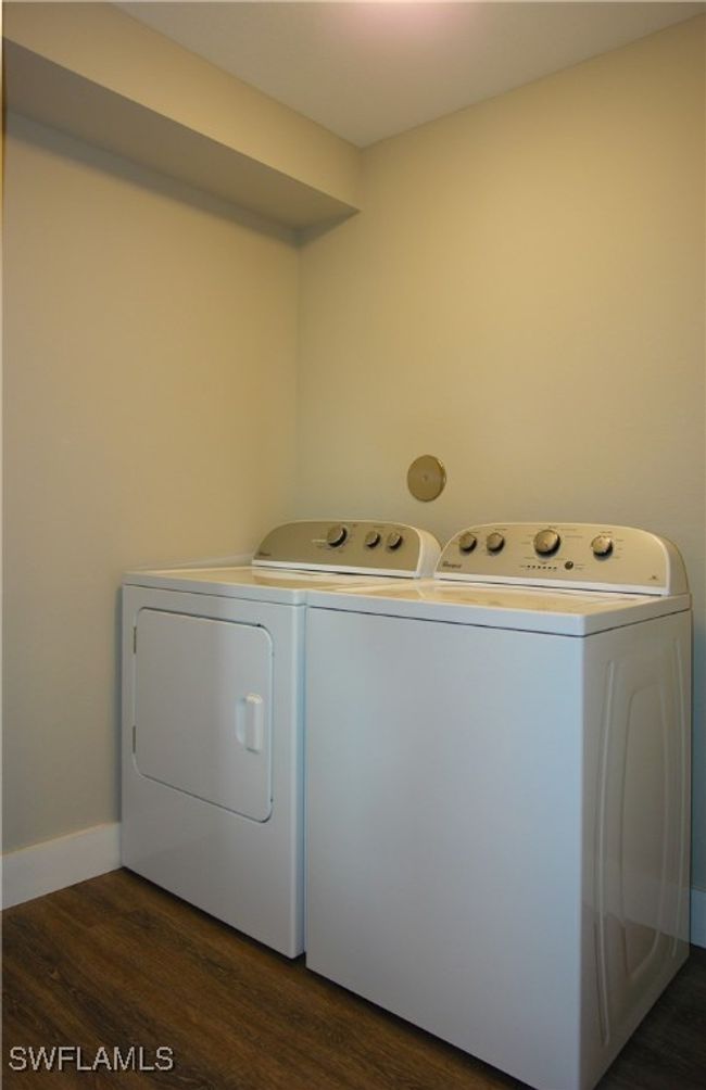 Laundry room featuring washing machine and clothes dryer and dark wood finished floors | Image 12