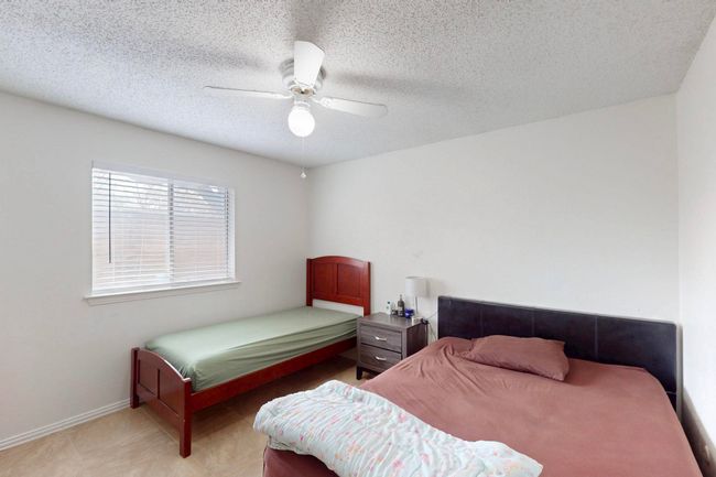 Bedroom with baseboards, ceiling fan, and a textured ceiling | Image 22