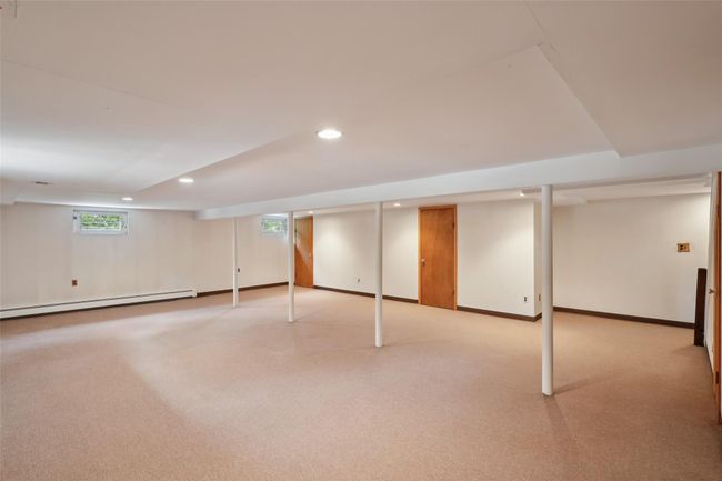 Below grade area featuring a baseboard heating unit, baseboards, light colored carpet, and recessed lighting | Image 31