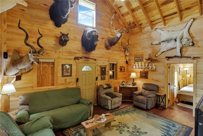 Living area with wood ceiling, wood walls, wood finished floors, high vaulted ceiling, and beam ceiling | Image 18