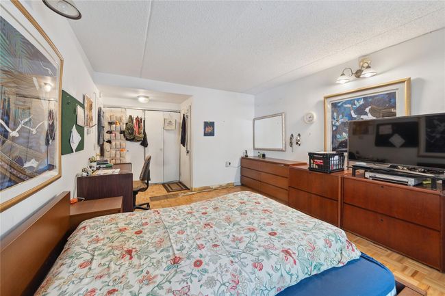 Bedroom with a textured ceiling, a closet, and an office area | Image 13