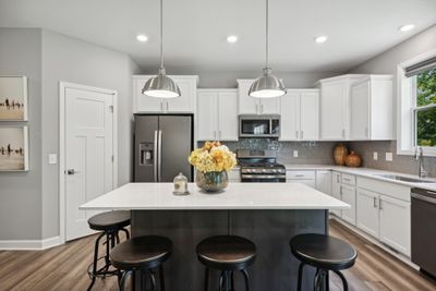 (Photo of model home, finishes will vary) This spacious kitchen features a large center island, quartz countertops, LVP floors, stainless appliances and more. | Image 1