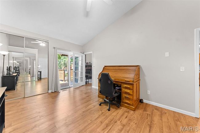 Bedroom being used as a home office with a ceiling fan, light wood-style floors, and high vaulted ceiling | Image 8