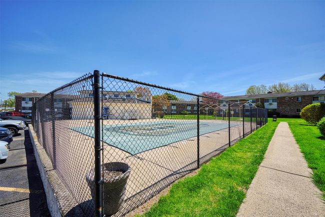 View of pool with fence and a tennis court | Image 15