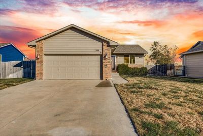 View of front of home featuring a garage and a yard | Image 1