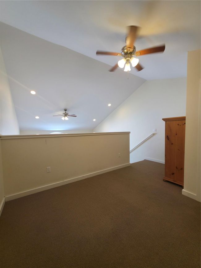 Bonus room with a ceiling fan, lofted ceiling, baseboards, and dark colored carpet | Image 17