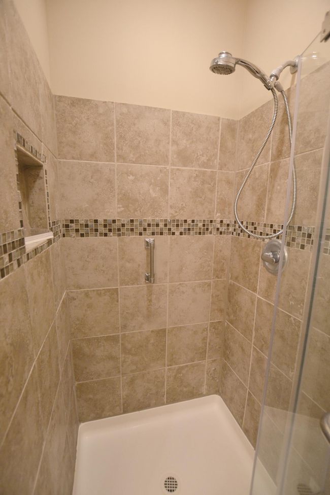 Enjoy a stylish ensuite shower featuring elegant tile work for a spa-like feel. | Image 10