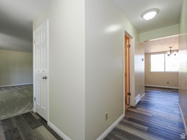 Hall featuring dark wood-type flooring and a chandelier | Image 27