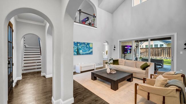 Living area with baseboards, stairway, a high ceiling, and wood finished floors | Image 7