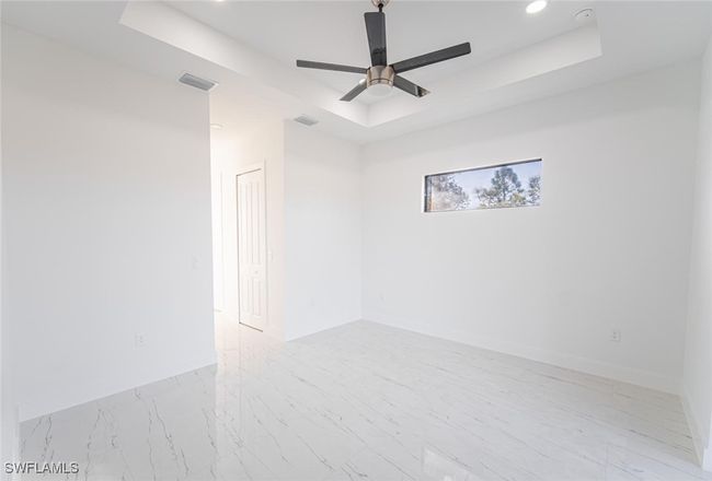 Empty room with a tray ceiling and ceiling fan | Image 10