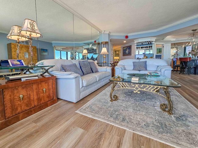 Living area featuring crown molding, a textured ceiling, and wood finished floors | Image 5
