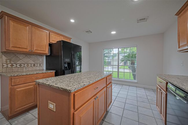 Spacious kitchen with granite countertops, breakfast area overlooking the large front and side yard, and refrigerator included! | Image 6