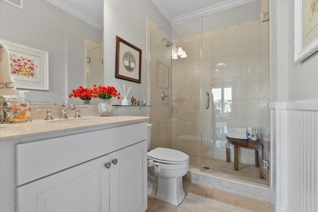 Bathroom featuring tile patterned flooring, ornamental molding, vanity, and a shower stall | Image 19