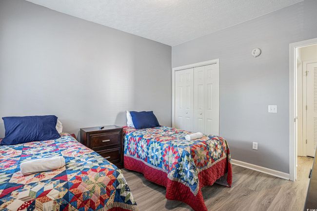 Bedroom with wood finished floors, a closet, and a textured ceiling | Image 16