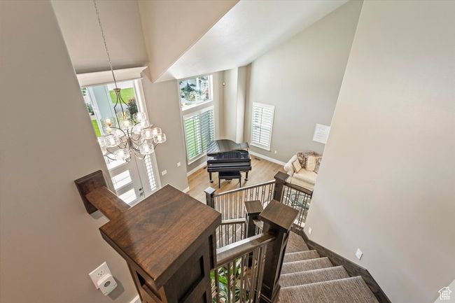 Staircase featuring high vaulted ceiling, a chandelier, baseboards, and wood finished floors | Image 38