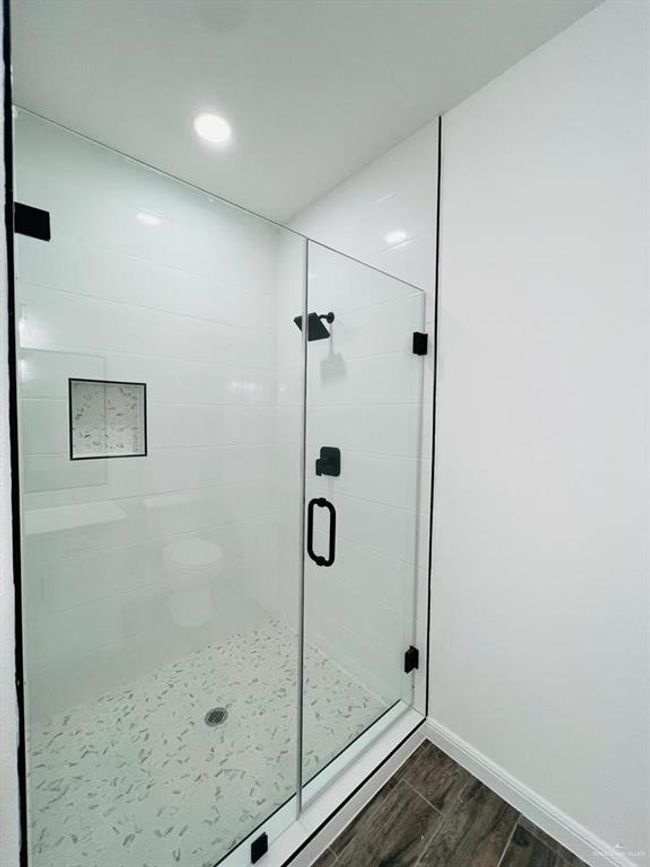 Bathroom with wood-type flooring and a shower with door | Image 17