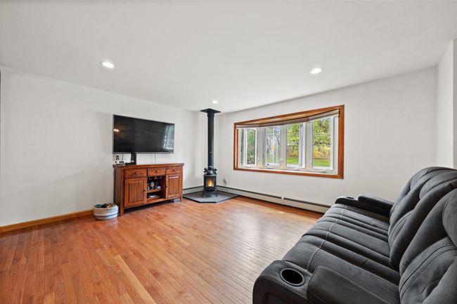 Living area featuring a baseboard radiator, light wood-style floors, and recessed lighting | Image 6