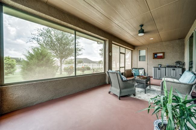 Sunroom / solarium featuring carpet, a ceiling fan, and a textured wall | Image 11