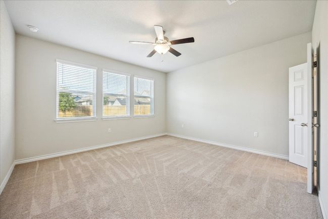 Empty room with ceiling fan, light colored carpet, and baseboards | Image 11