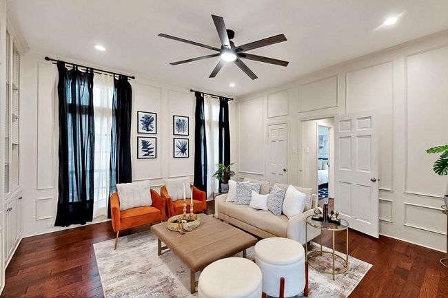 Living area featuring a decorative wall, dark wood-type flooring, a ceiling fan, and recessed lighting | Image 4