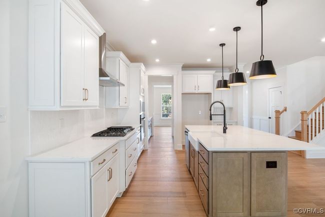 Photo represents the plan, not the actual home. Design selections may vary. A spacious kitchen with an island and pantry open to an adjoining dining area and the family room. | Image 9